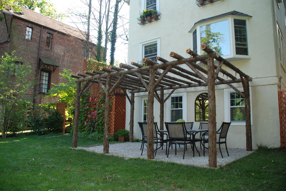 Rustic natural pergola made from bark-on cedar logs, twigs, and branches titled the Larchmont
