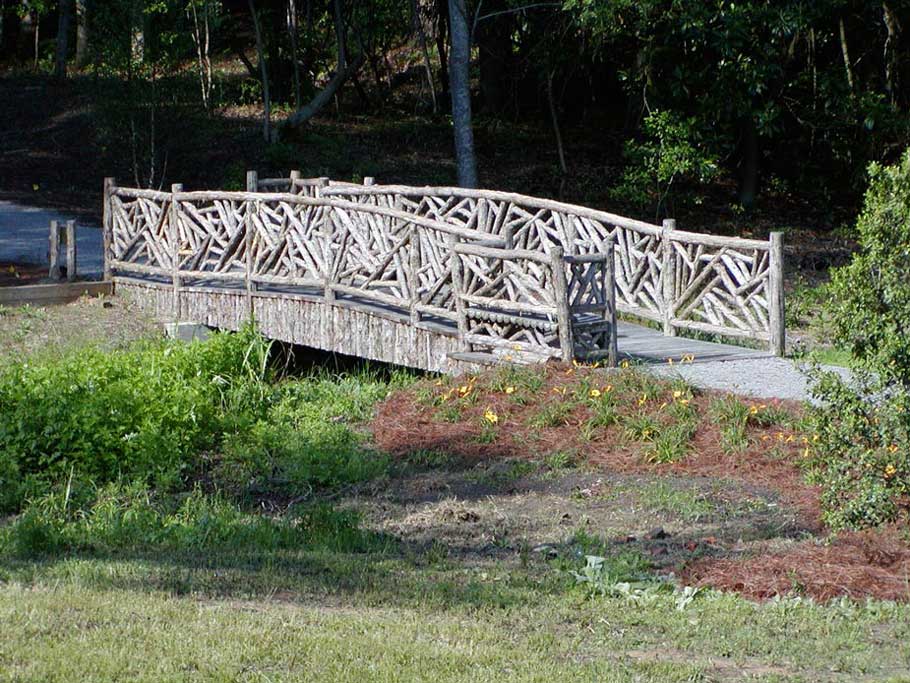 Rustic bridge built using bark-on trees and branches at the Village Arboretum in Pinehurst NC