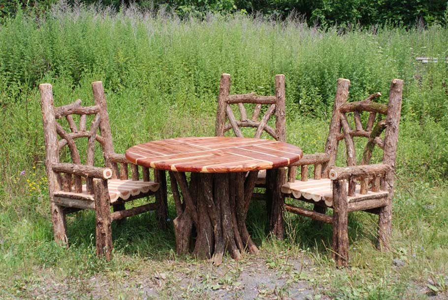 Natural wood chairs and table built with bark-on trees and branches titled the Bear Chair Dining Set
