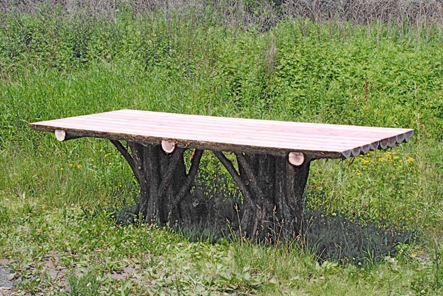 Outdoor rustic table built using bark-on trees and branches titled the Lamondo Table