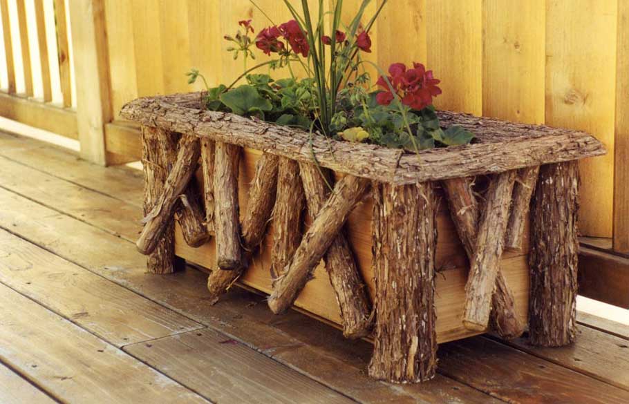 A small flower planter with a removable insert constructed using bark-on cedar trees and branches