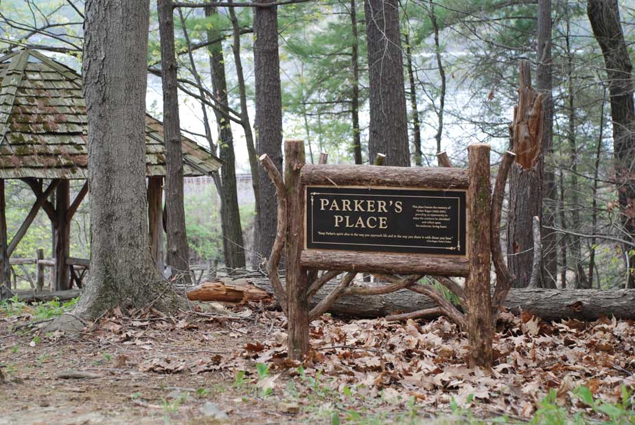 A park location sign built with bark-on eastern red cedar trees and branches