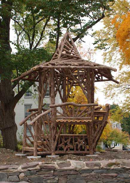 Unique rustic garden structure built using bark-on trees and branches titled the Carousel House