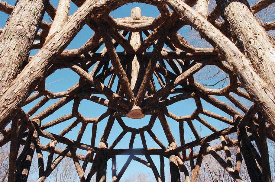 A detail of a gazebo roof built in the rustic style using logs and branches installed at Chui's Summerhouse