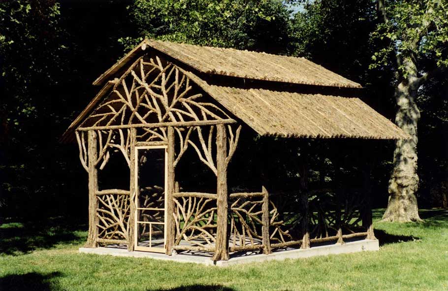 A large rustic dining pavilion built using bark-on trees and branches titled the Rumson Pavilion