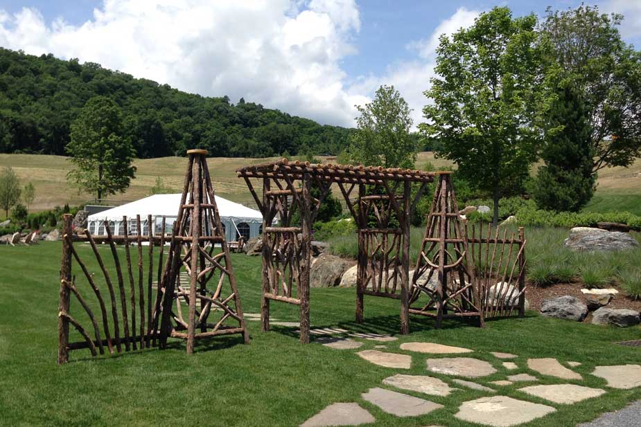 Rustic tepees, fencing, and arbor custom built using cedar trees and branches displayed at Silo Ridge Country Club