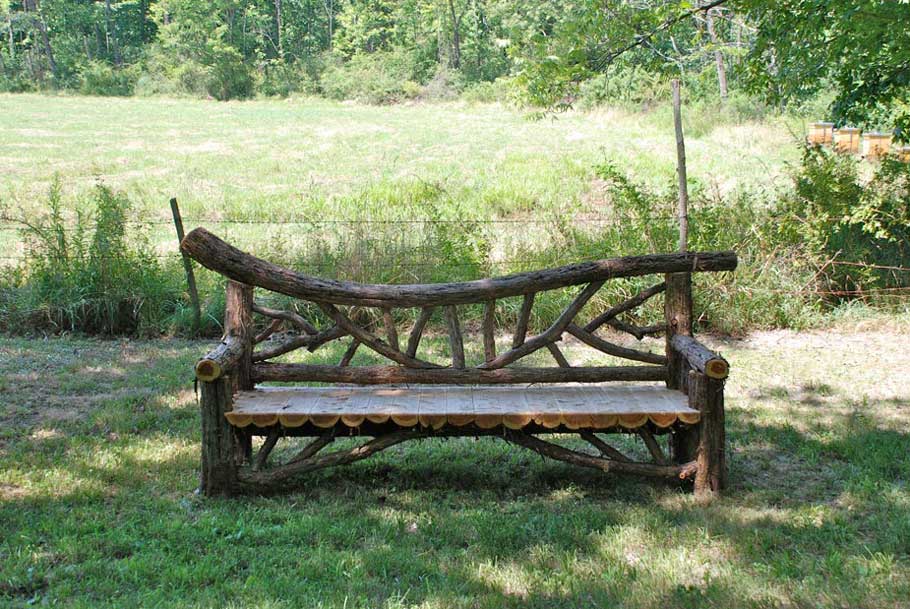 Rustic bench custom built using cedar trees and branches titled the Falling Waters