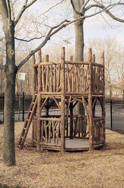 Outdoor rustic play tower built using bark-on trees and branches built for Easton Children's Museum